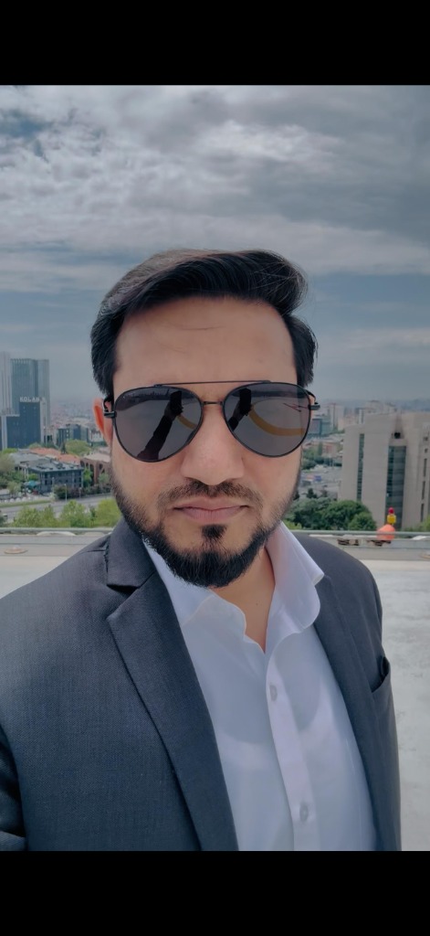 Ajaz Ahmad outdoors, with a city skyline behind him