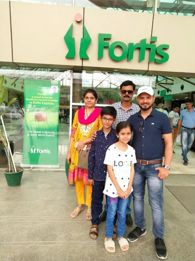 A family standing at a hospital entrance